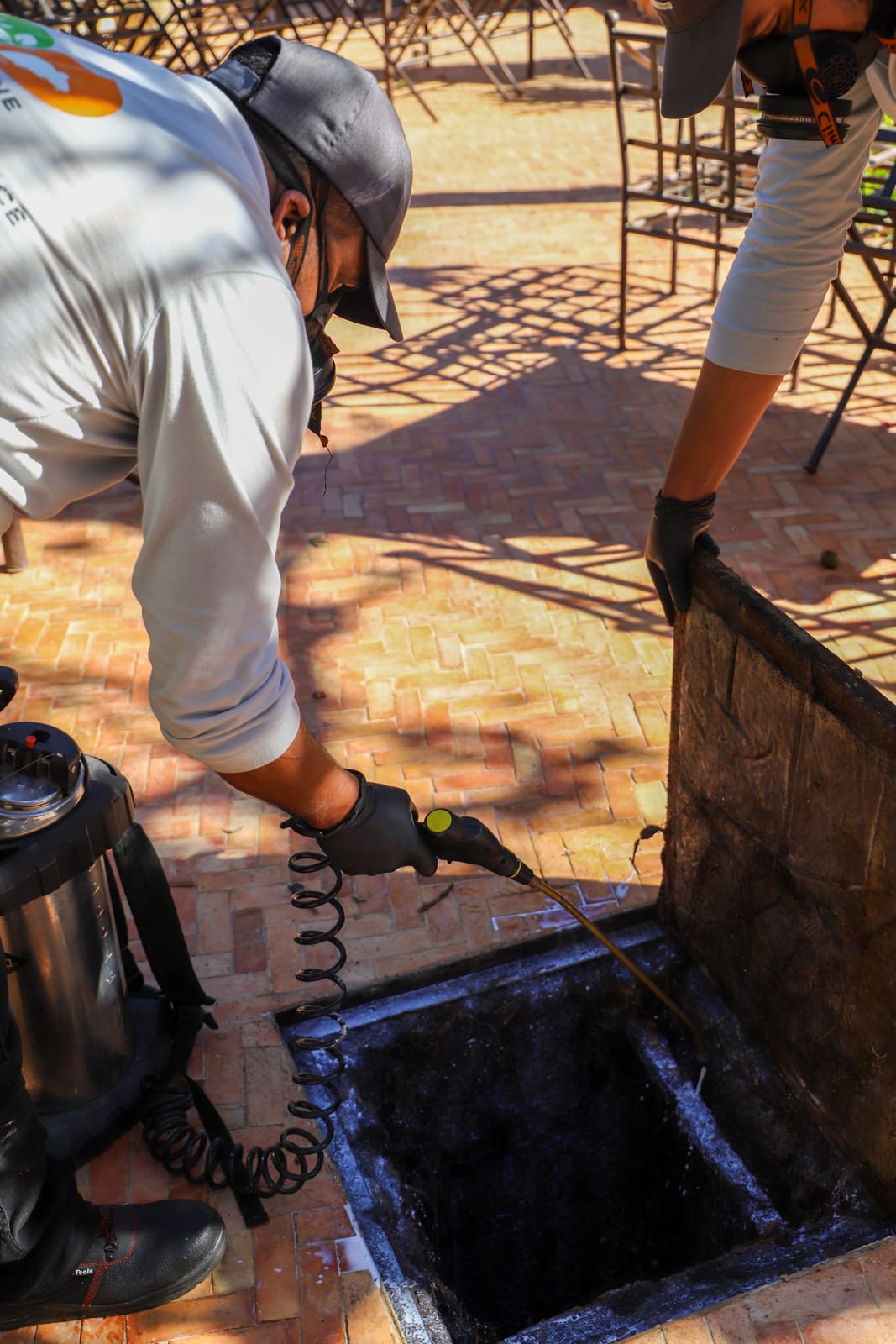 Technicien HPS traitant un regard d'évacuation sur une terrasse en zellige à Essaouira