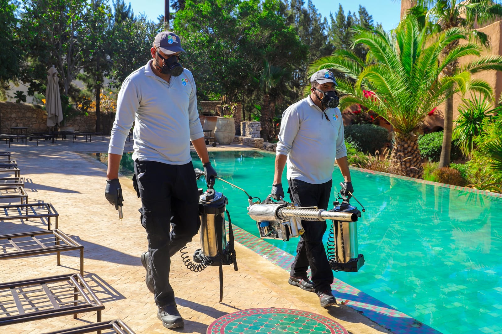 Techniciens HPS longeant la piscine d'un hôtel d'Essaouira, matériel de traitement en main