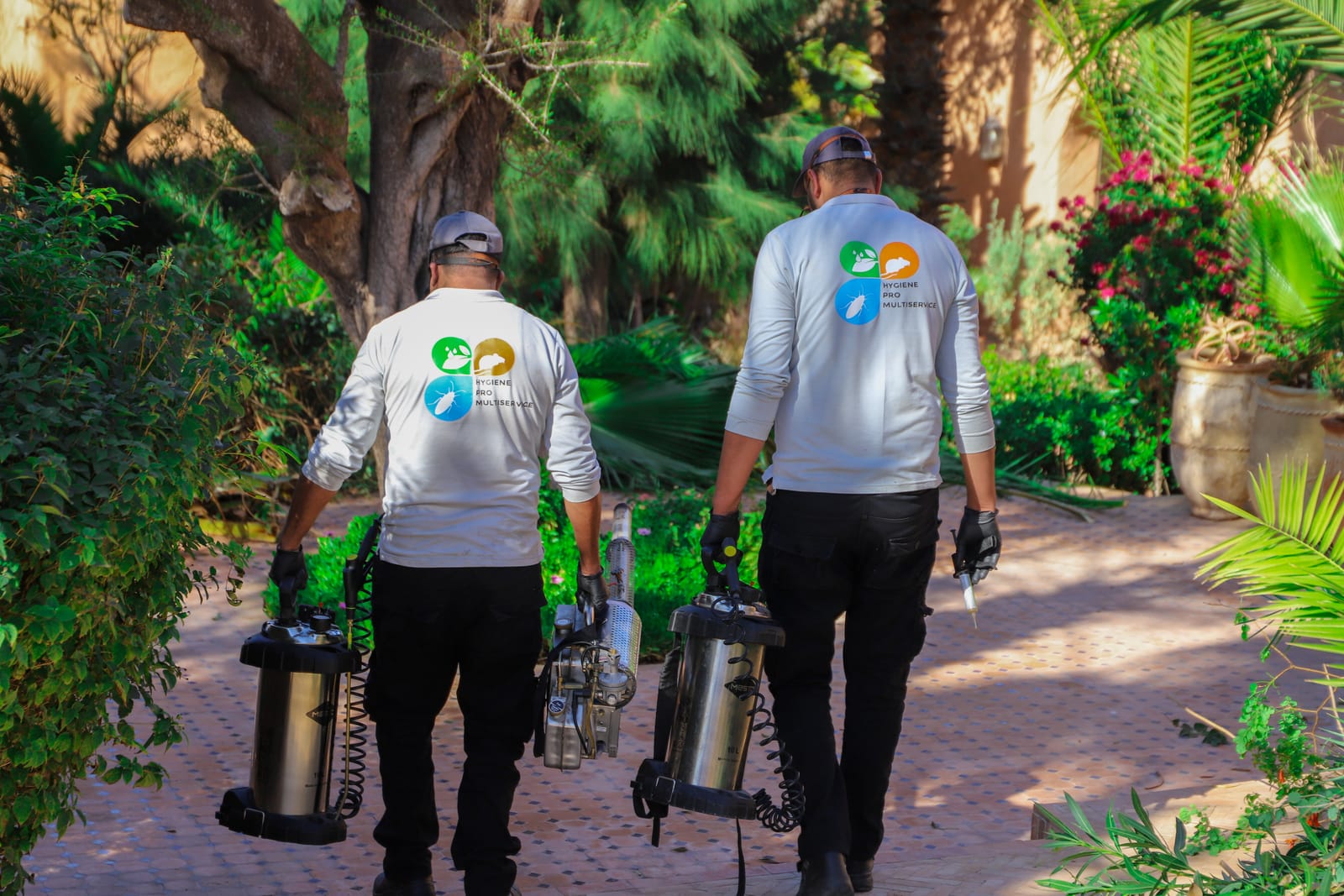 L'équipe Hygiène Pro Multiservice en uniforme, logo au dos, en intervention dans un jardin d'Essaouira